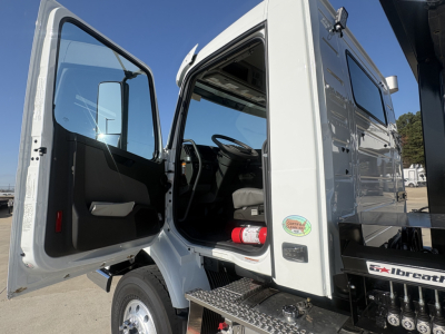 Volvo VHD64B300 cab interior view with driver door open showing dashboard, steering wheel, and entry step area.