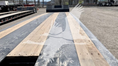 Trailer deck close-up showing wooden planks and steel edges on a Fontaine Renegade N12 lowboy trailer deck.