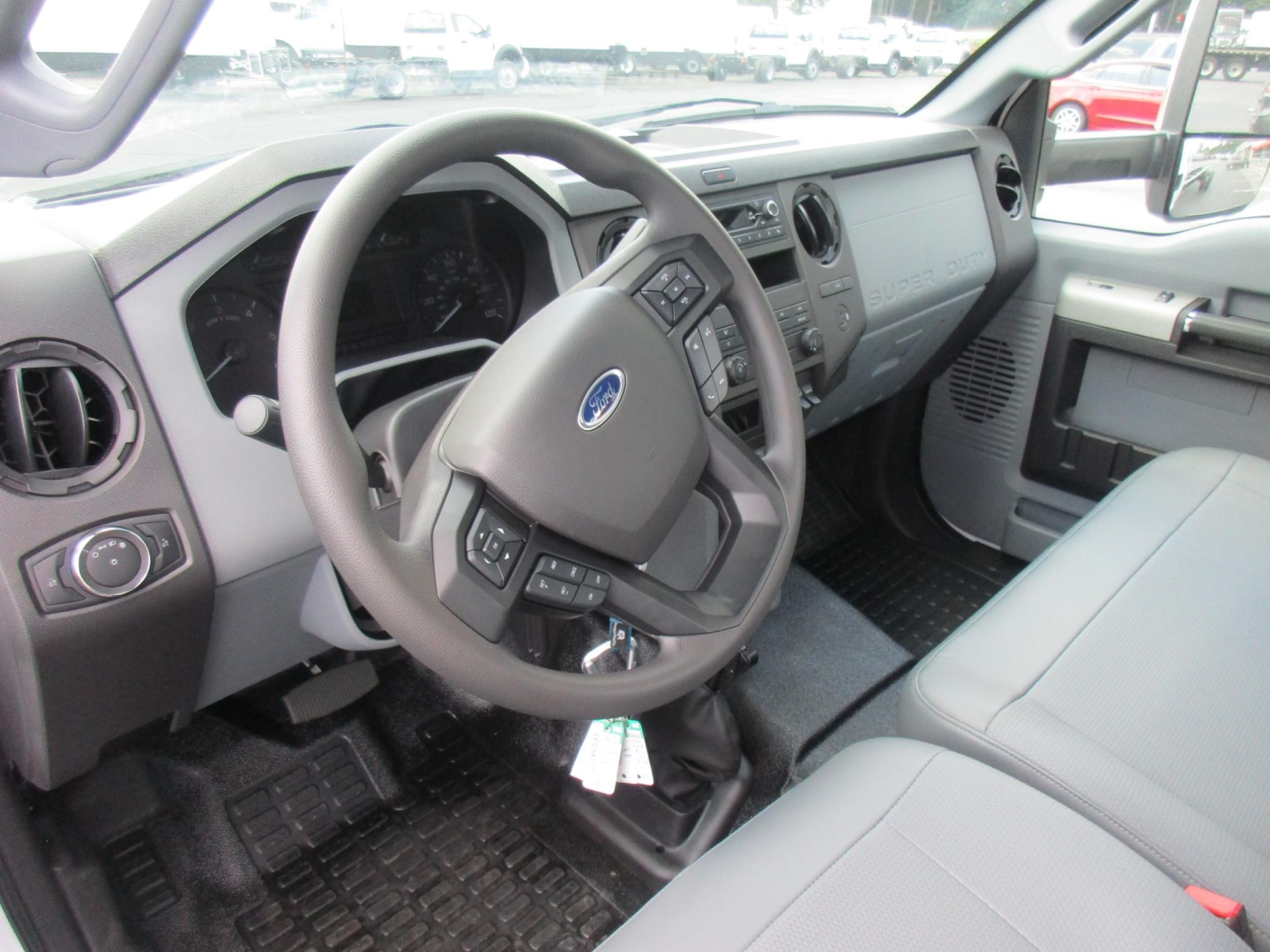 Ford F-650 cab and chassis interior showing steering wheel and dashboard with gray seats and center console.