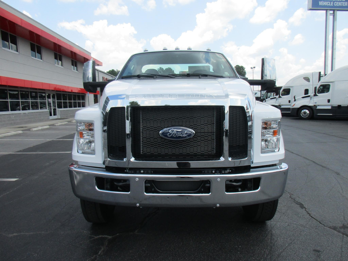 Ford F-650 cab and chassis front view showing large black grille, Ford emblem, and chrome bumper.