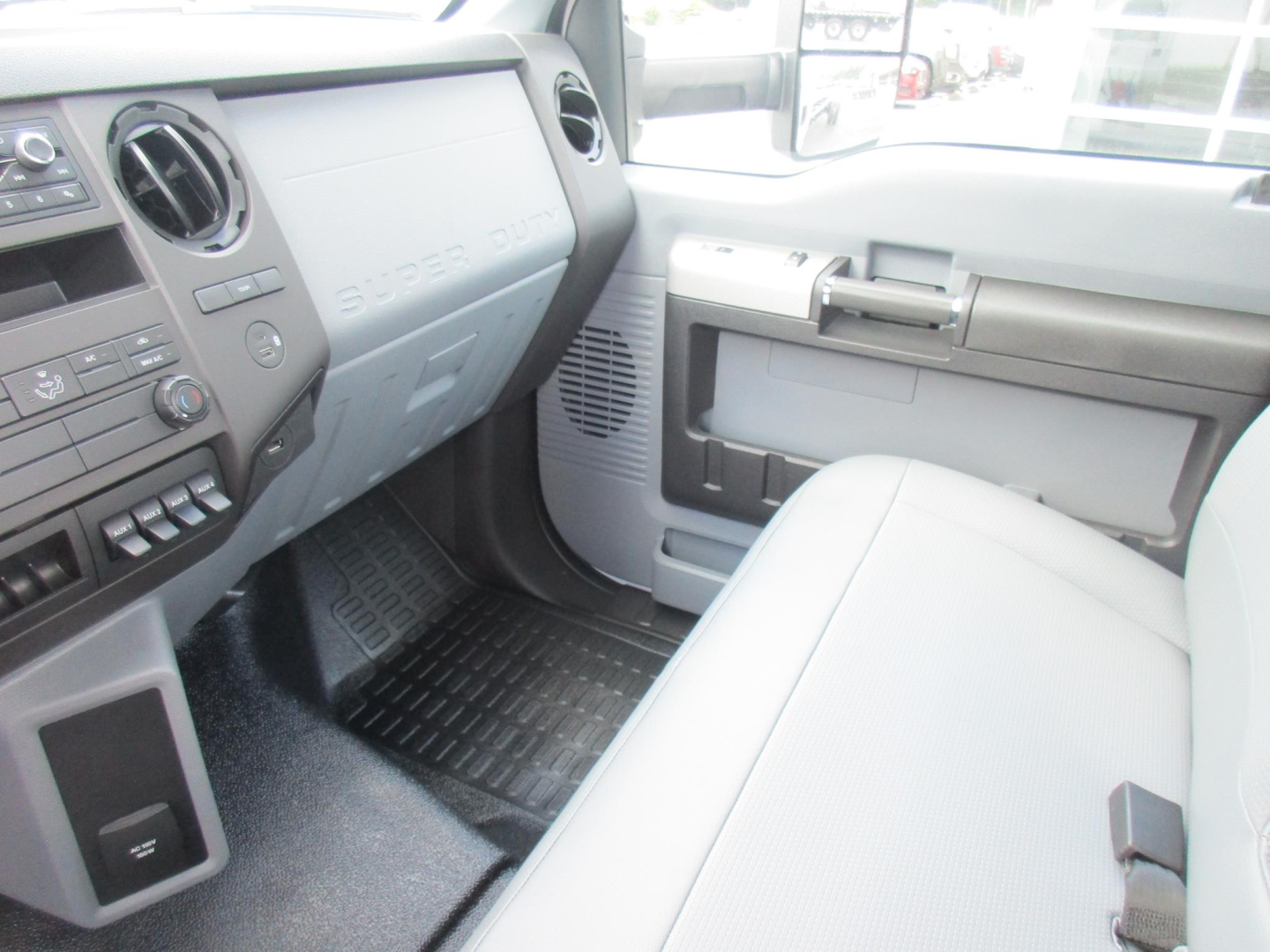 Ford F-650 SD cab interior showing dashboard passenger side and front bench seat with gray trim and floor mats.