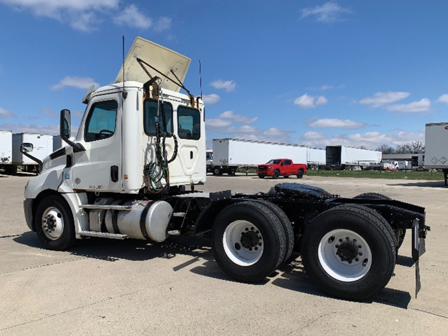 Side view of a Freightliner Cascadia126 tractor with a raised hood and exposed cab, showing two rear axle wheels and chassis; visible text not legible on image.