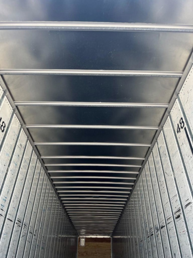 Interior trailer van cargo area with ribbed ceiling and side walls, perspective view down the length.
