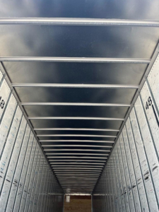 Interior trailer van cargo area with ribbed ceiling and side walls, perspective view down the length.