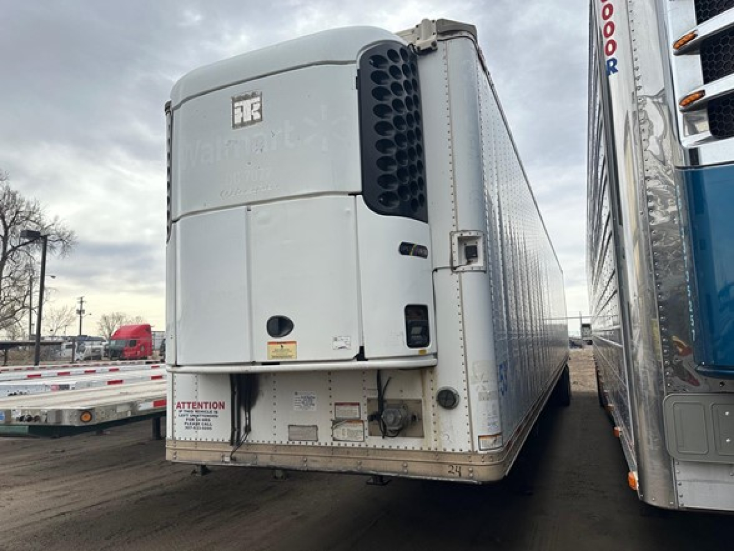 Trailer rear view showing a Great Dane roll door multi temp reefer with large side cooling unit, white exterior, stock number UE10775, VIN 150114098700