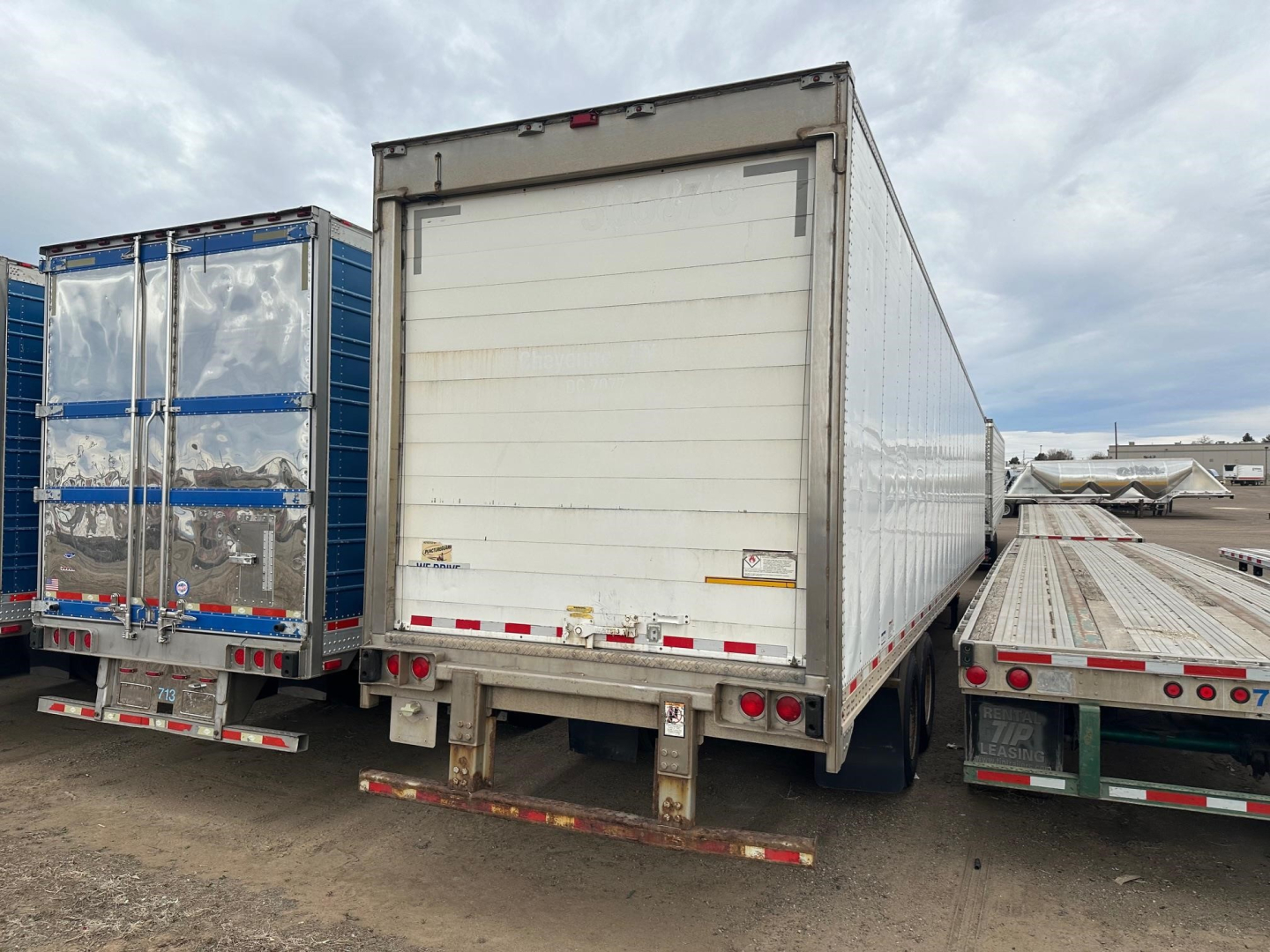 Great Dane roll-door semi-trailer reefer with white rear door and multi-temperature capability, parked among other trailers.
