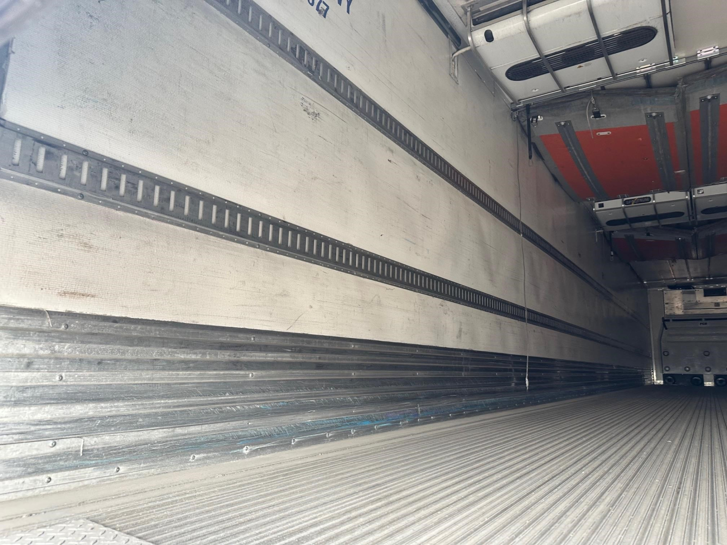Trailer interior showing open cargo area with ribbed metal floor and side rails for a Great Dane roll door reefer.