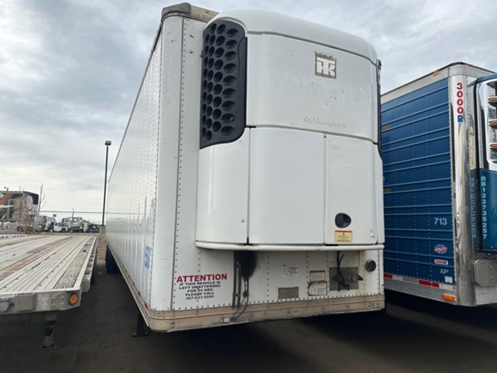 Great Dane reefer trailer rear view with multi-temperature unit and HR logo, white exterior, attention label near bumper, loading dock area.