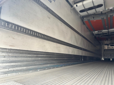 Trailer interior showing open cargo area with ribbed metal floor and side rails for a Great Dane roll door reefer.