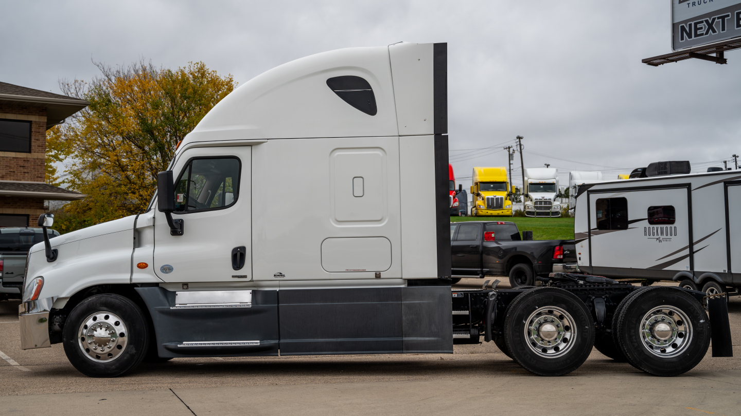 Freightliner Cascadia 125 tractor-trailer side view showing sleeper cab and fuel tanks.