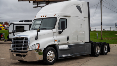 Freightliner Cascadia 125 semi-truck cab in white, side view showing sleeper cab, dual rear axles, chrome bumper and mirrors.