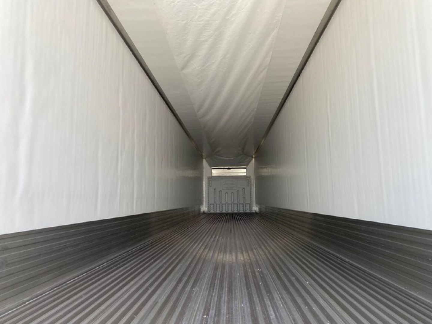 Trailer interior view of a new 2027 Utility reefer, empty cargo area with clean white walls and ribbed metal floor.
