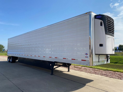 Utility reefer trailer with Carrier refrigeration unit mounted at front showing insulated side panels and standard dual rear axles.