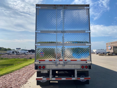 Rear view of a new 2027 utility refrigerated trailer with diamond plate aluminum doors, bumper with reflectors, and safety lights.