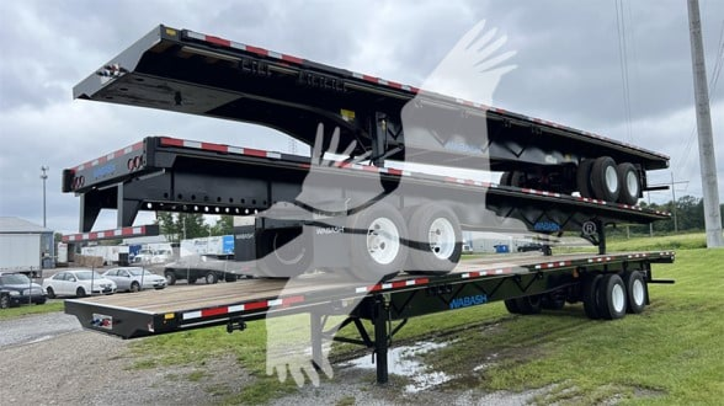 Trailer side view showing a raised Wabash Steel air slider flatbed trailer with dual tandem axles