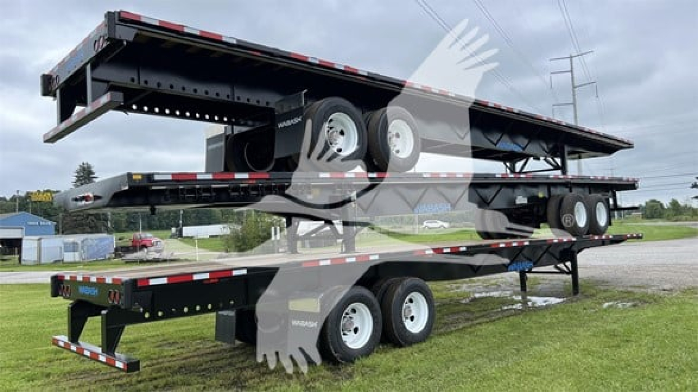 Trailer stack showing a used 2024 Wabash Steel Air Slider flatbed trailer on a triple-axle setup with multiple lines and wheels.