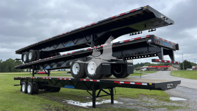 Wabash air slider trailer stacked on a flatbed trailer, multiple axles, aluminum wheels, and black frame with white rims.
