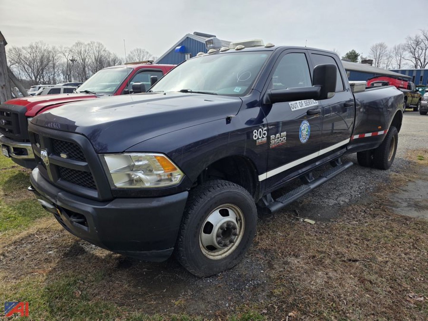 Ram 3500 pickup truck in a used lot, dark blue/black exterior, single cab, utility decals on front door, 4x4 badge, cargo bed visible.