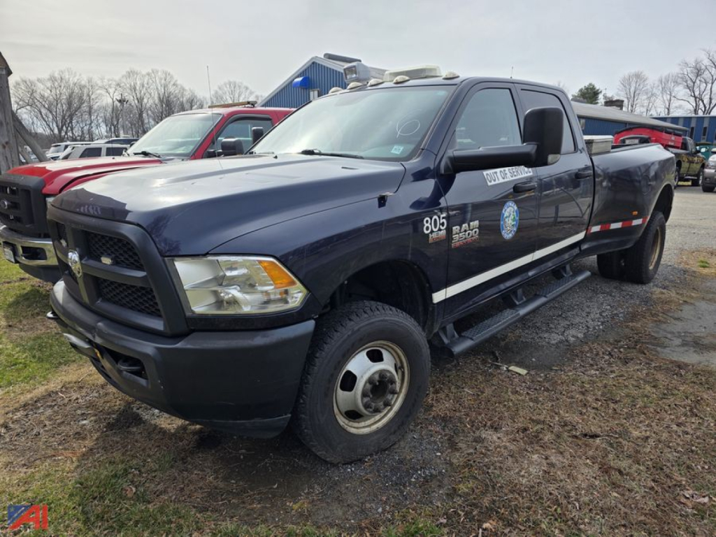 Ram 3500 pickup truck in a used lot, dark blue/black exterior, single cab, utility decals on front door, 4x4 badge, cargo bed visible.