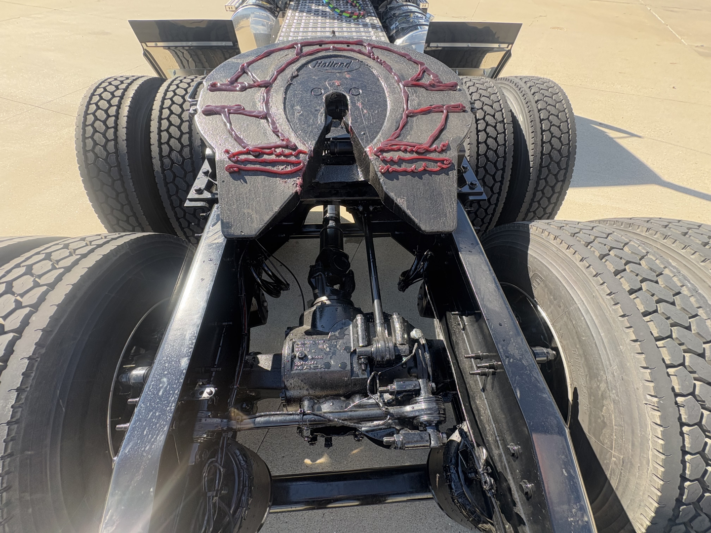 Mack PI64T tractor chassis rear view showing fifth wheel and drivetrain components.