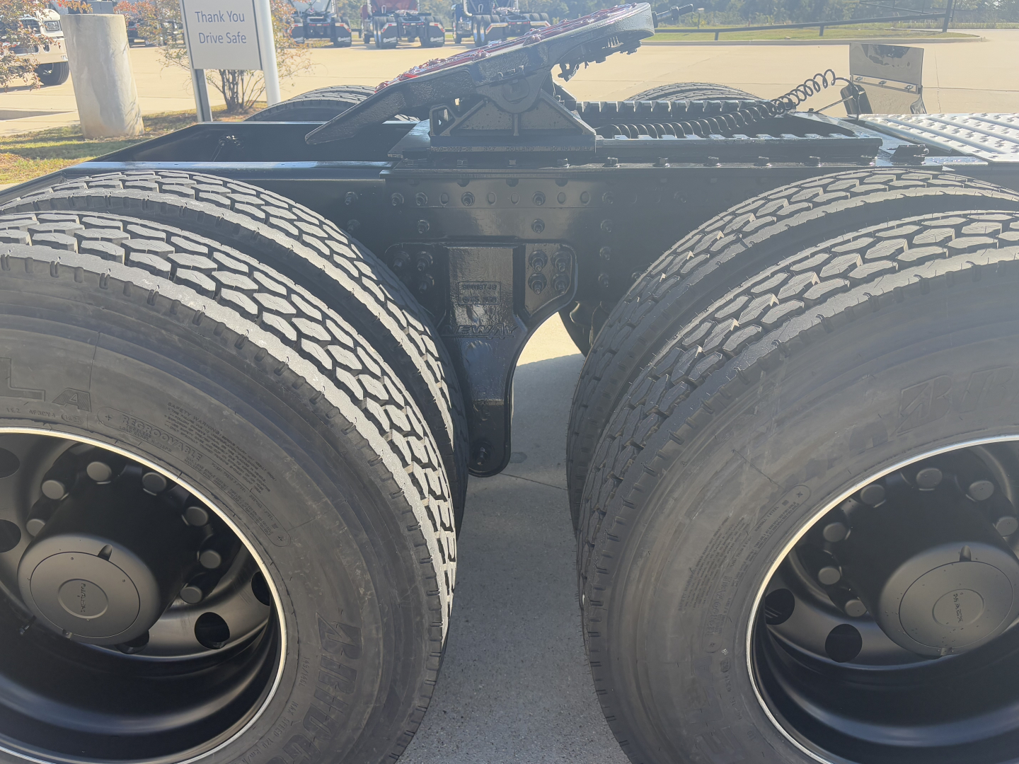 Dual rear axles of a Mack PI64T tractor showing the fifth wheel, frame rails, and dual tires. No legible labels visible in the image.