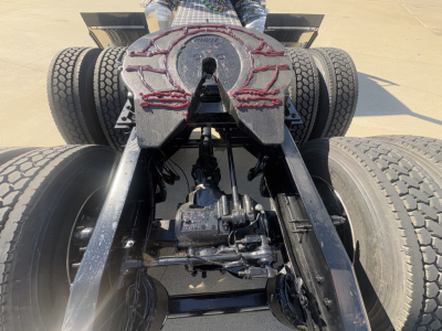 Mack PI64T tractor chassis rear view showing fifth wheel and drivetrain components.