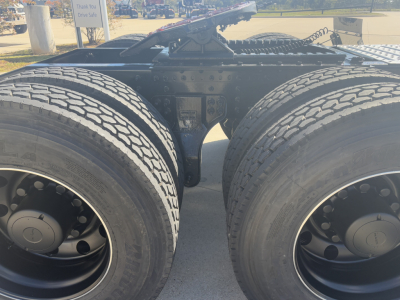 Dual rear axles of a Mack PI64T tractor showing the fifth wheel, frame rails, and dual tires. No legible labels visible in the image.
