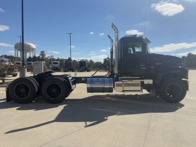 Mack PI64T truck chassis side view showing cab, dual rear axles, fuel tanks, and exhaust stacks.