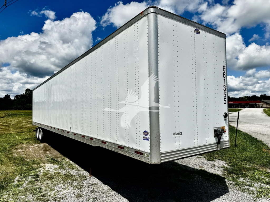 box trailer showing white utility dry van with rear doors and DOT markings.