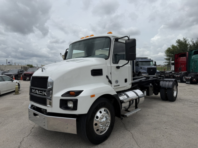 Mack MD6 hooklift truck in a lot showing front-left view with white cab and chrome bumper.