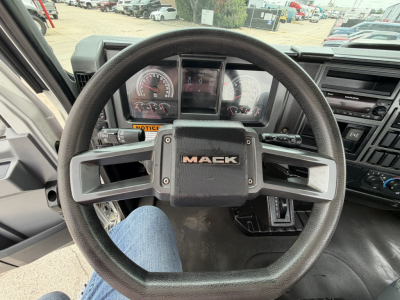 Mack MD6 truck steering wheel and instrument cluster seen from driver seat with dashboard controls.