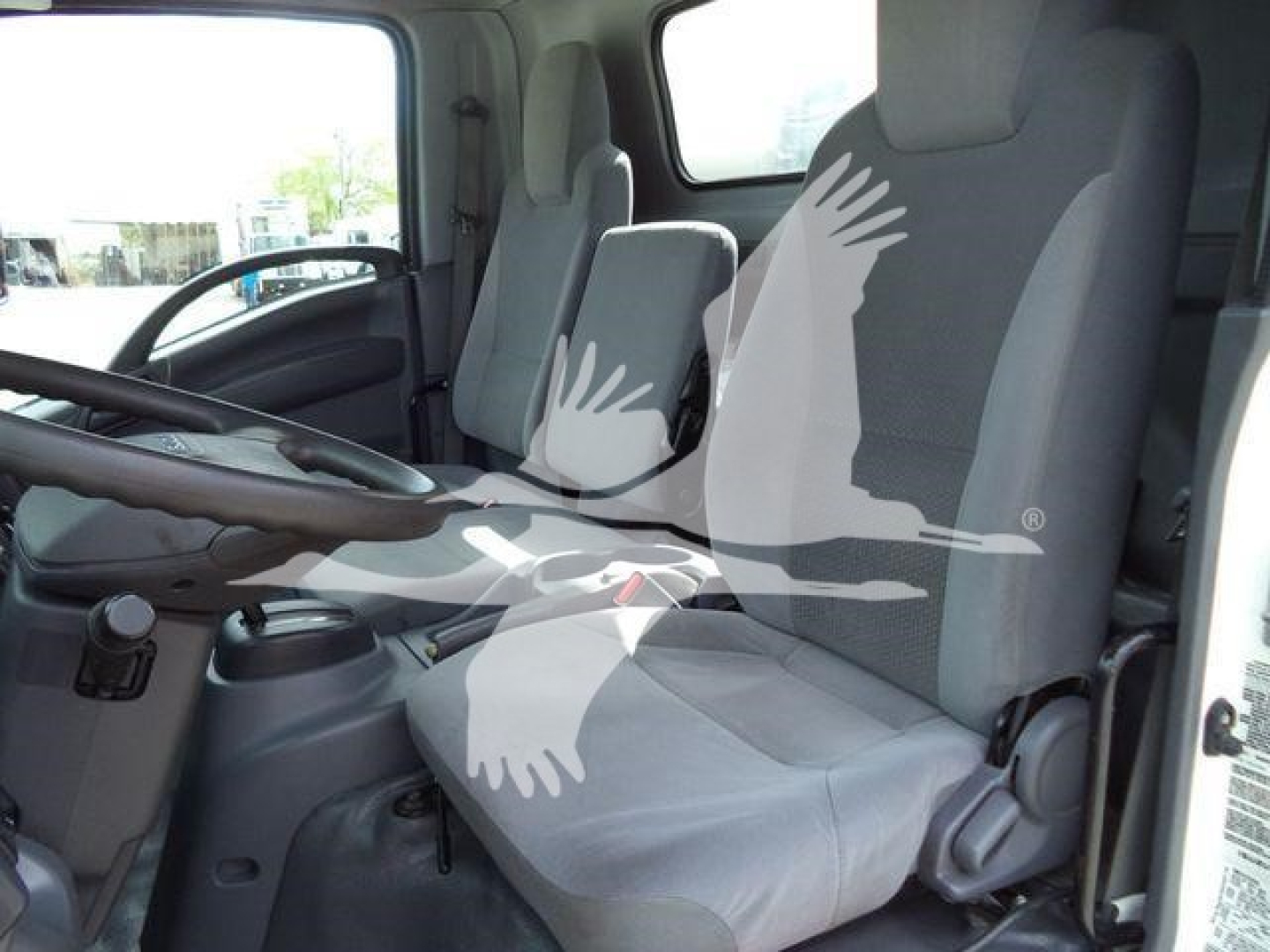 Isuzu NPR HD truck interior showing driver and passenger seats with steering wheel and dash visible.