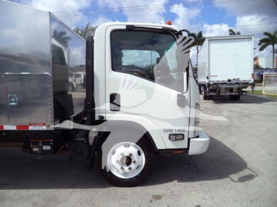 Isuzu NPR HD truck cab side view showing GVW 14500 label and door; front wheel and side mirror visible; cargo box reflection in shiny surface.