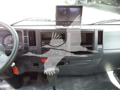 Isuzu NPR HD dashboard view showing steering wheel, instrument cluster, center stack, and a mounted GPS/tablet on the dash.