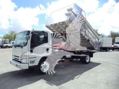 Isuzu NPR HD dump truck with raised dump bed and cab visible, reflections on surface, truck in a lot.