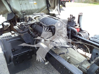 Isuzu NPR HD truck chassis with engine and hydraulic lines visible, showing exposed engine bay and drivetrain components.