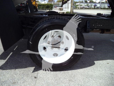 Isuzu NPR HD chassis with wheel and tire showing a white steel wheel and partial frame.