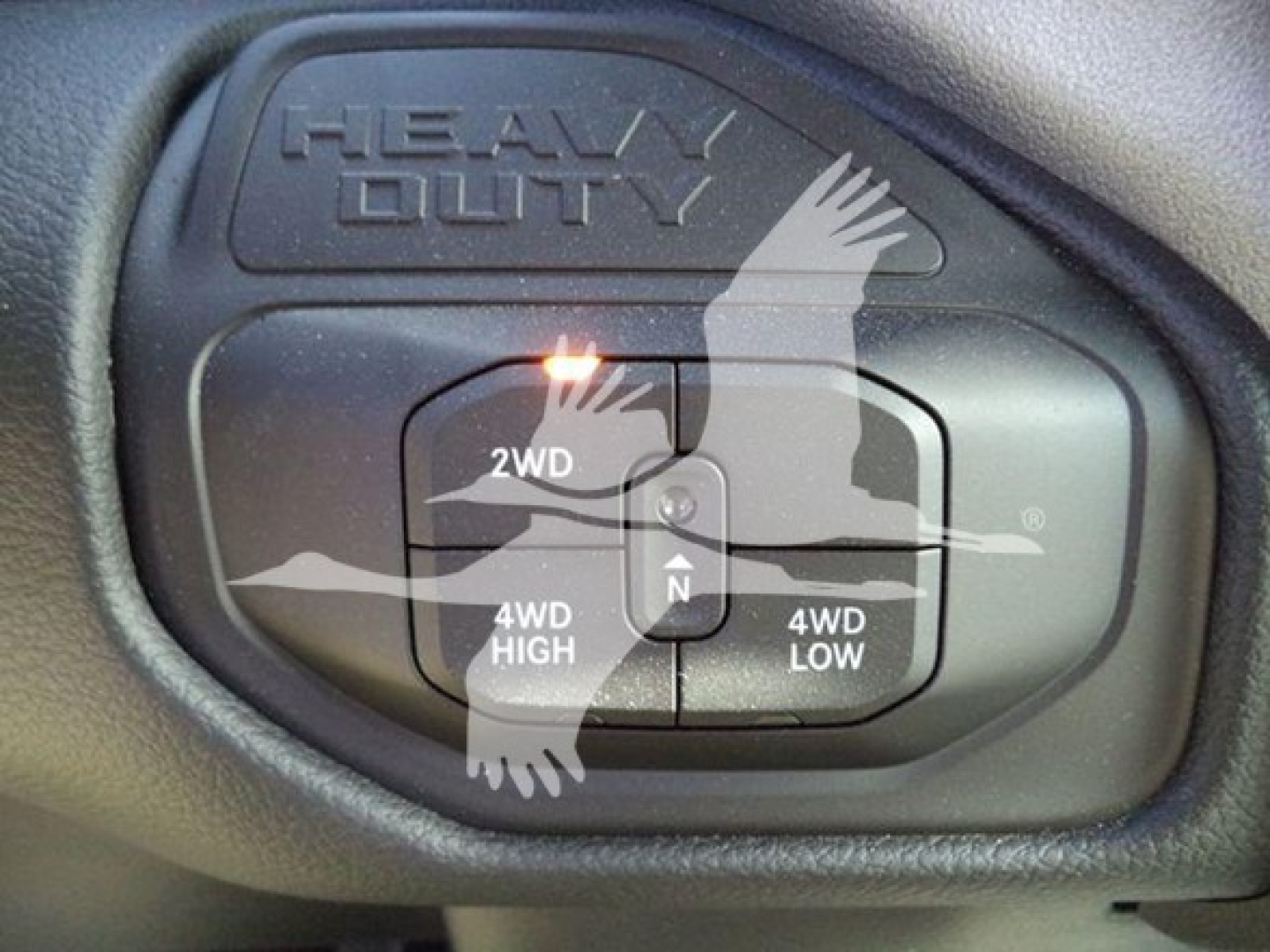 Ram truck interior control panel showing 2WD, 4WD HIGH, 4WD LOW, and 4WD with a graphic of a bird overlay on the switch.