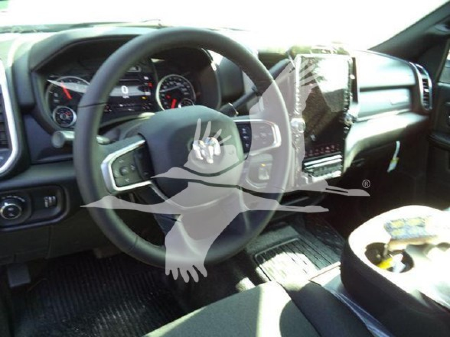 Ram pickup interior showing steering wheel, dashboard, and center console with touchscreen display.
