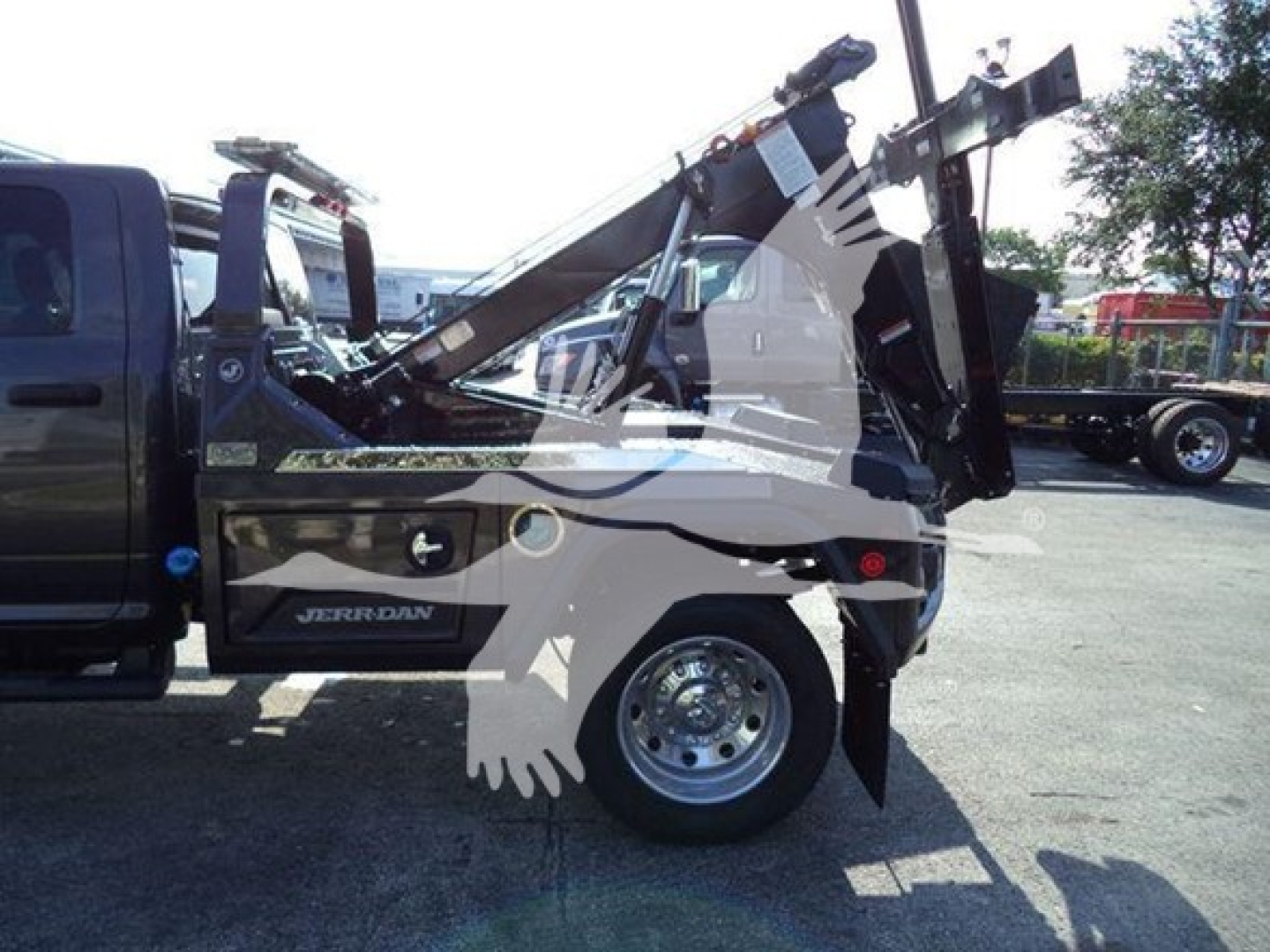 Ram 2500/3500 service truck rear-side view showing winch bed and hydraulic hoist with RAM badging.