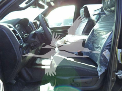 Ram truck interior view showing front seats and steering wheel with plastic seat covers.