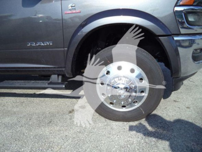 Ram truck front wheel well and brake disk with Ram logo badge and chrome wheel, side view showing RAM badge and 4x4 badge.