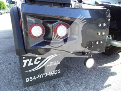 Winch-equipped Ram truck rear showing dual red circular lights and TLC Truck & Equipment sign with phone number 954-979-9422.