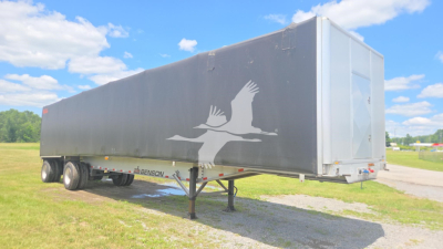 Conestoga curtainside trailer showing Benson logo on gray tarp and rear hatch, triple-axle flatbed with landing gear extended.