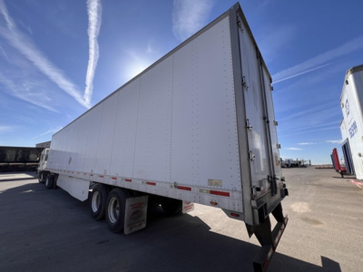 Utility dry van trailer with rear swing doors, three-axle undercarriage, side reflective tape and DOT bumper.