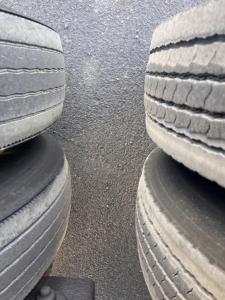 Rear viewing angle of utility trailer tires showing tread and gap between wheels.