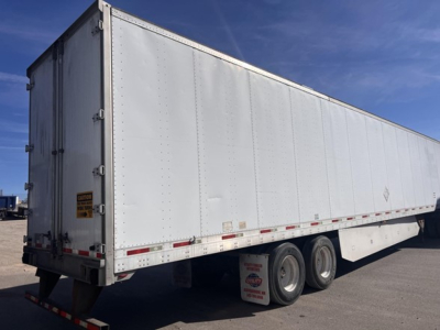 Trailer showing side view of a white dry van with rear swing doors, three axles, and reflective striping.