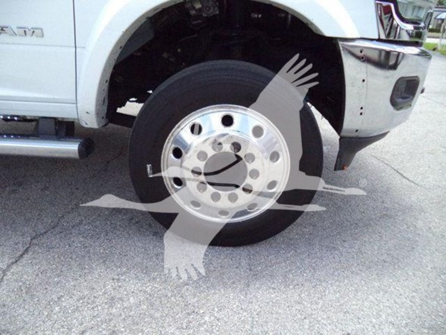 Ram front wheelwell and tire on white 2021 Ram SLT pickup, partial front bumper and fender visible