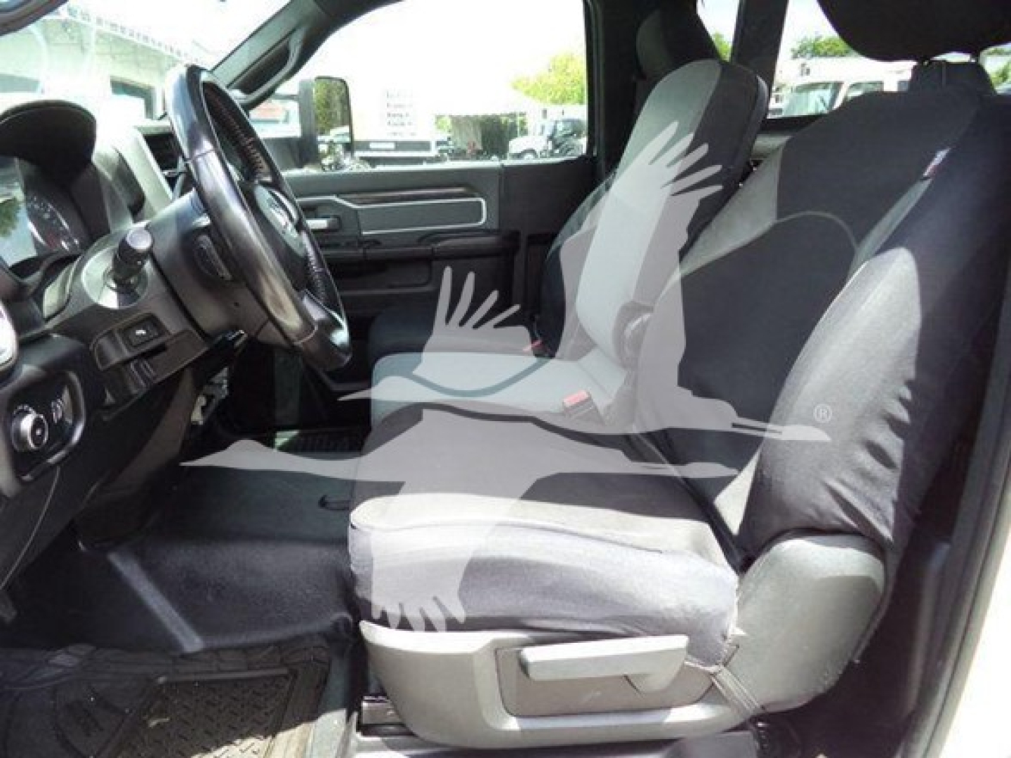 Interior view of a 2021 Ram SLT truck showing front driver's seat and passenger seat with steering wheel and dashboard visible.