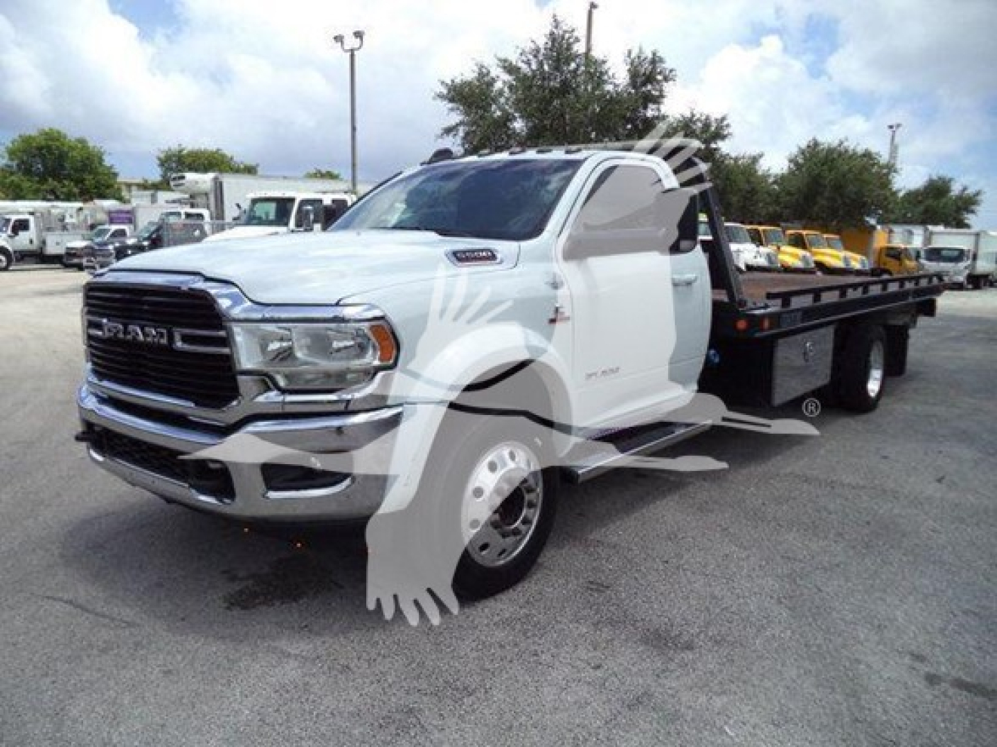 Tow truck deck on a white 2021 Ram SLT cab with rollback bed, front grille shows RAM emblem, side view, VIN tag and stock number not visible.